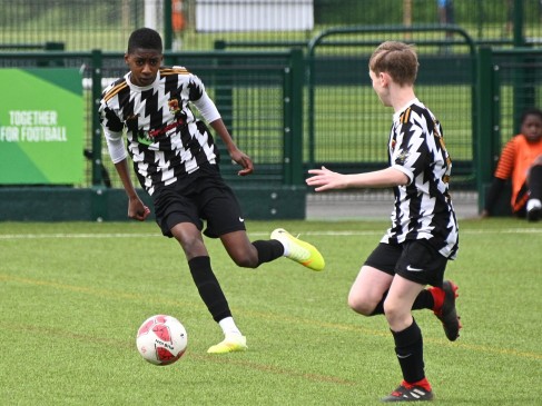 Two players in black and white pass and receive the ball