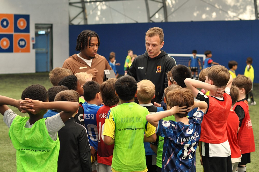 Group of children with coach and Mika Hamilton