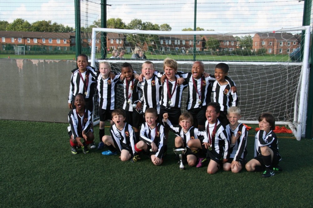 Group of young football players wearing black and white striped tops